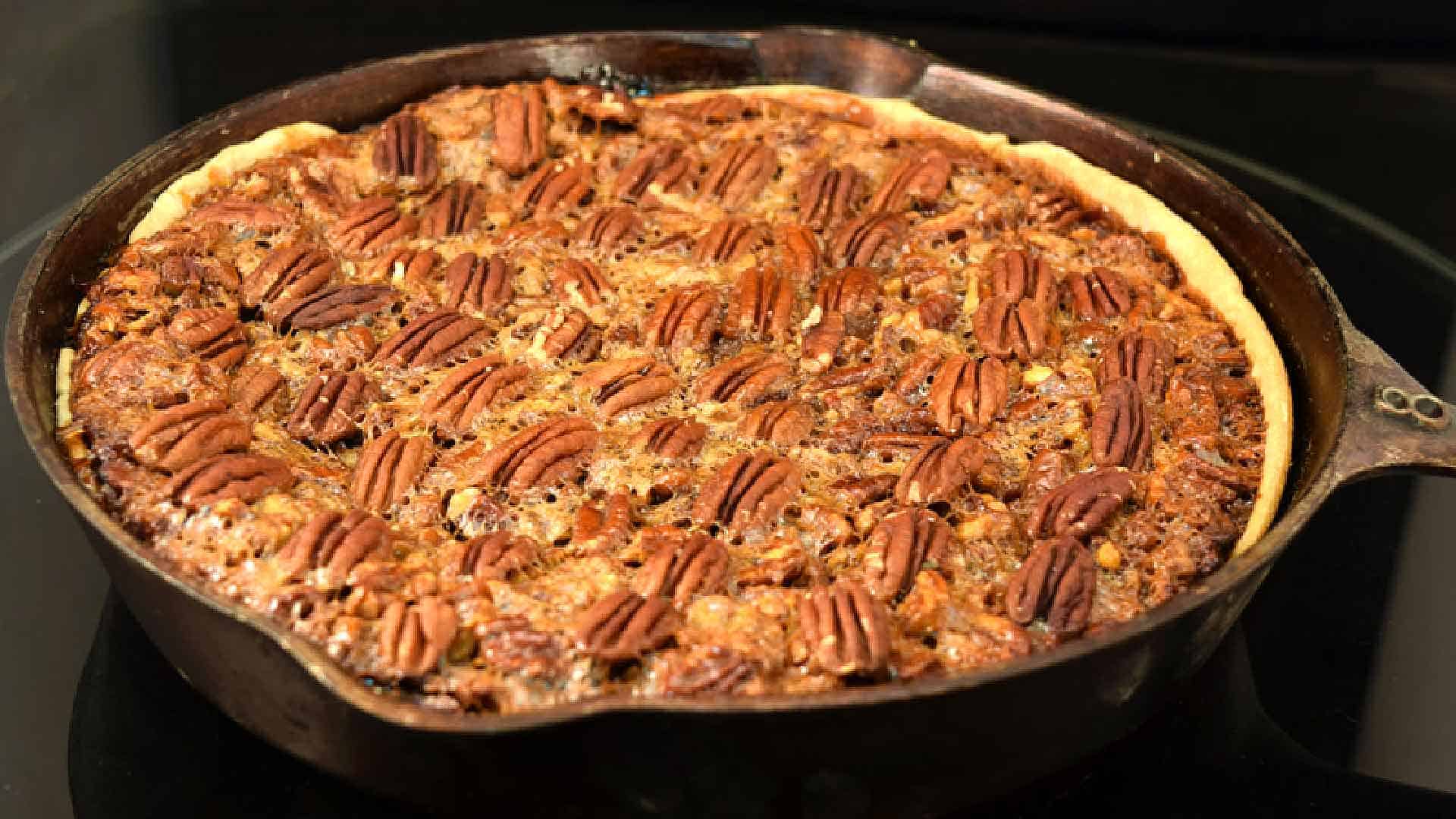 Butterscotch pecan pie on the grill in a cast iron skillet.