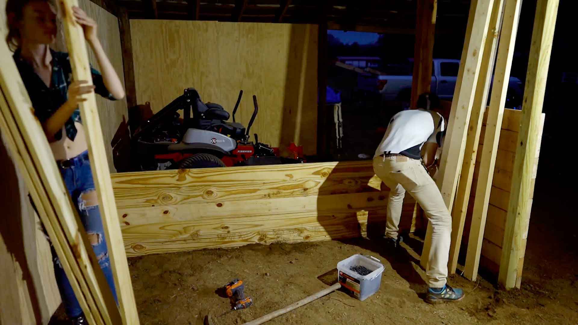 Willow Hand and Josh Knight building walls for a horse stall.