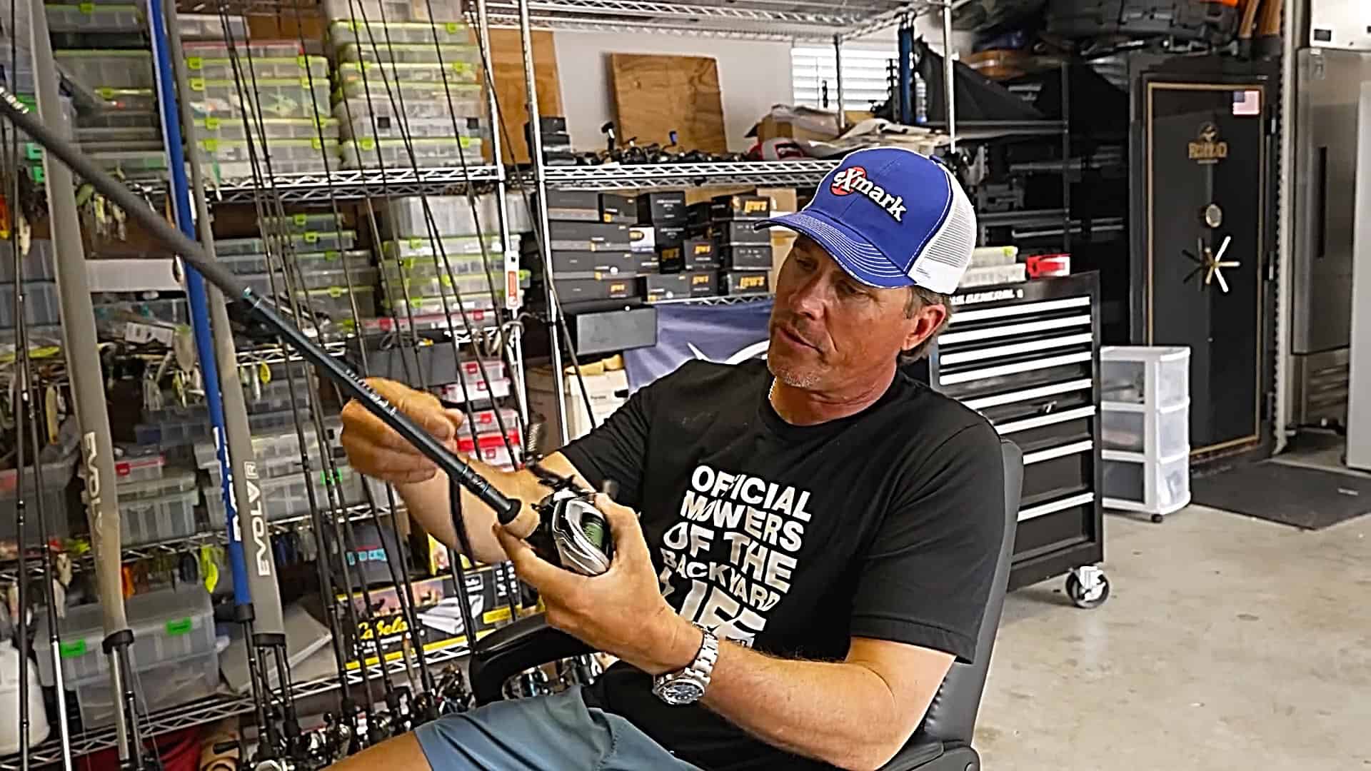 Scott Martin holding a fishing rod in his garage