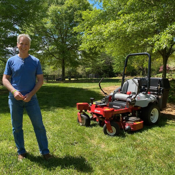 Joe Lamp'l standing in front of mower in yard