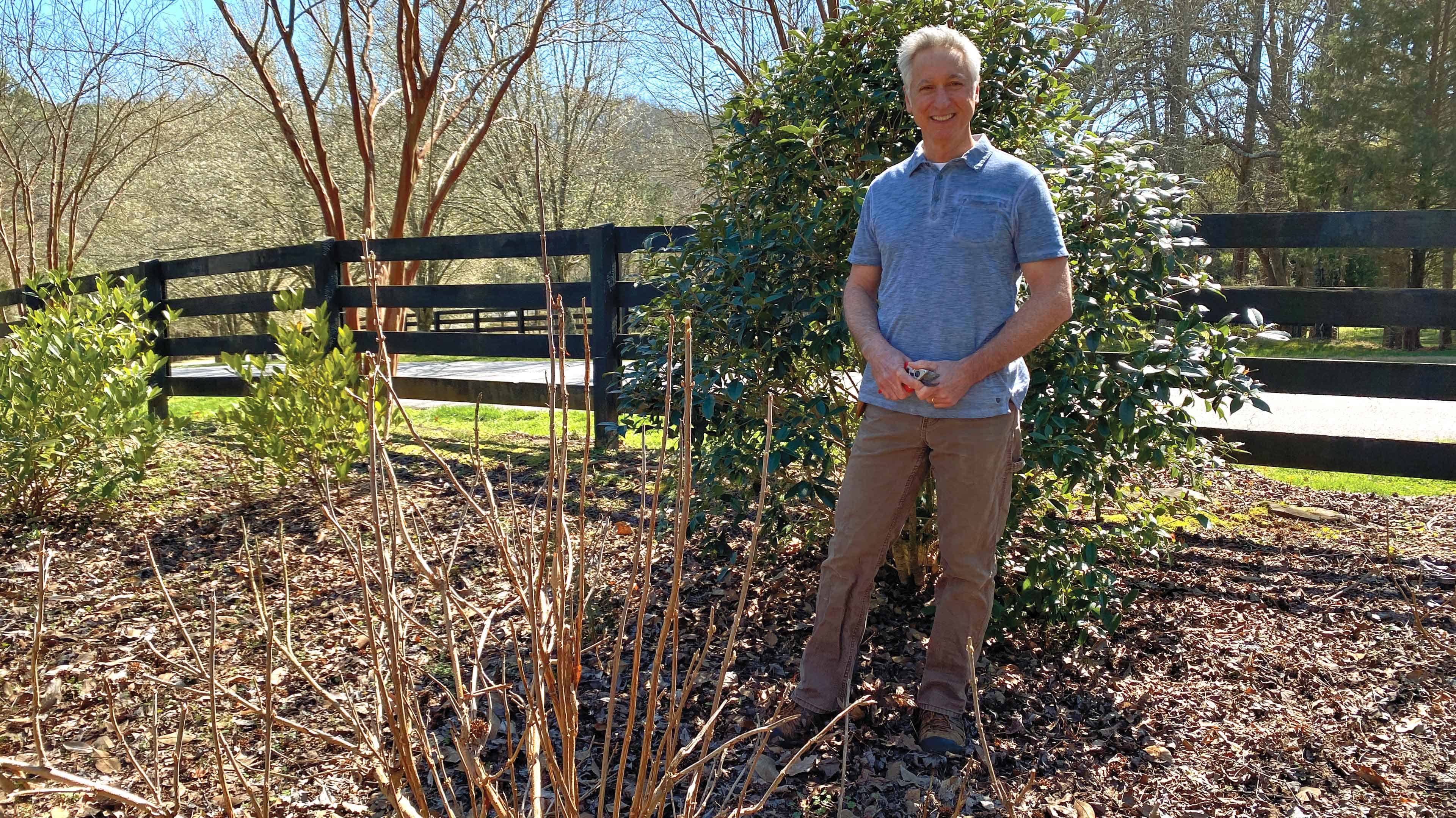 Joe standing in front of a bush