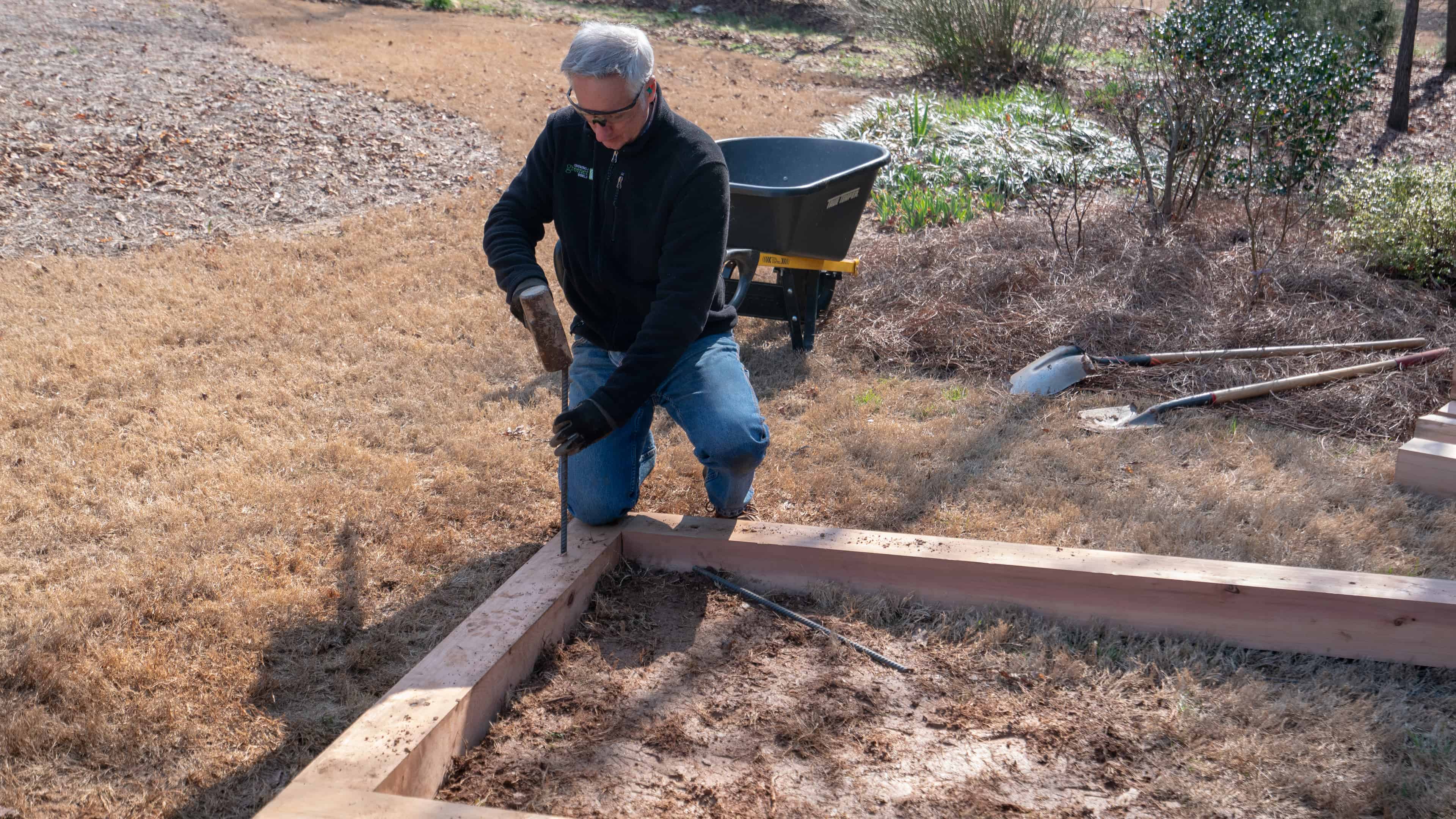Hammering in stakes for raised garden bed