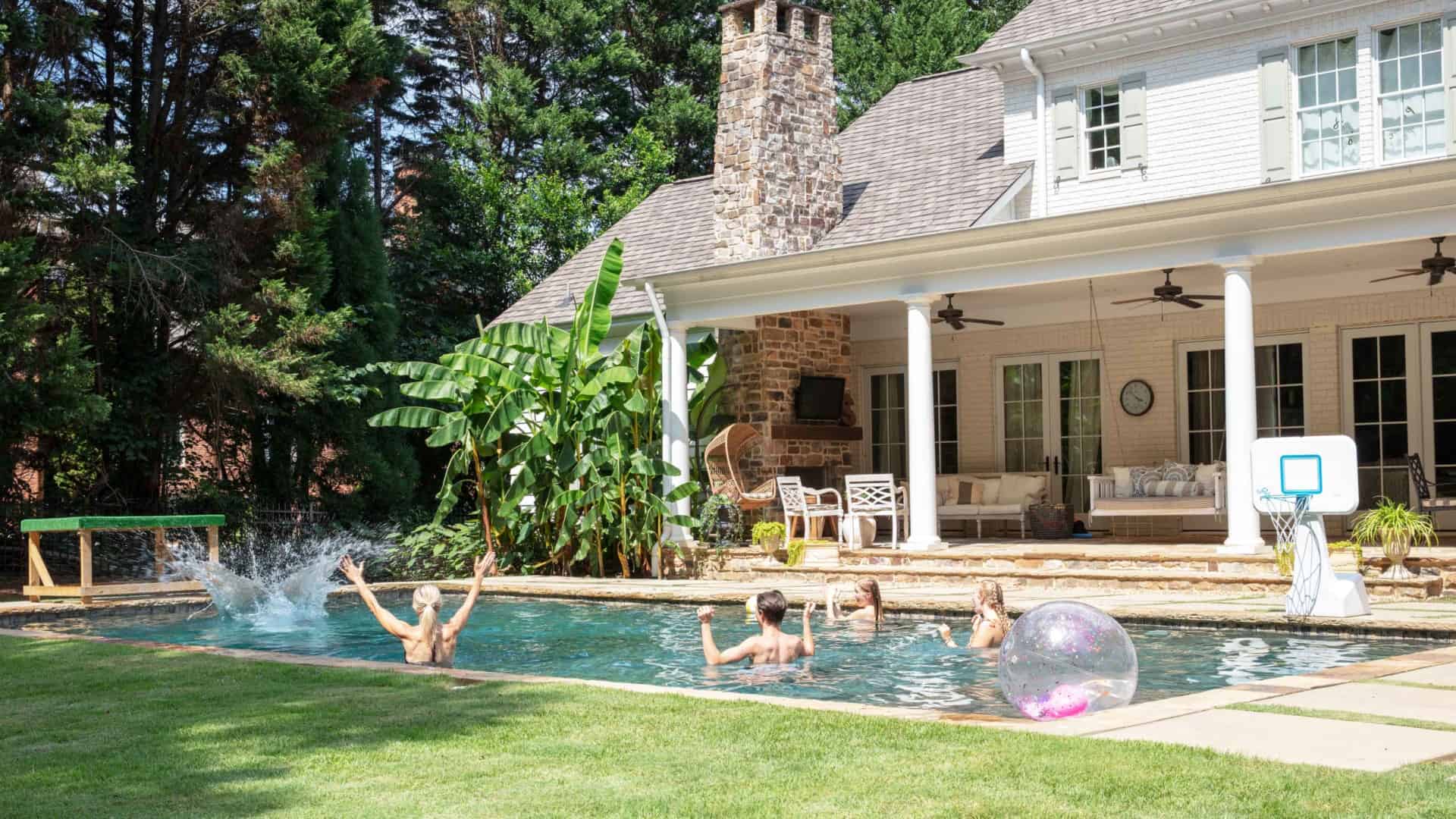 People swimming in backyard pool
