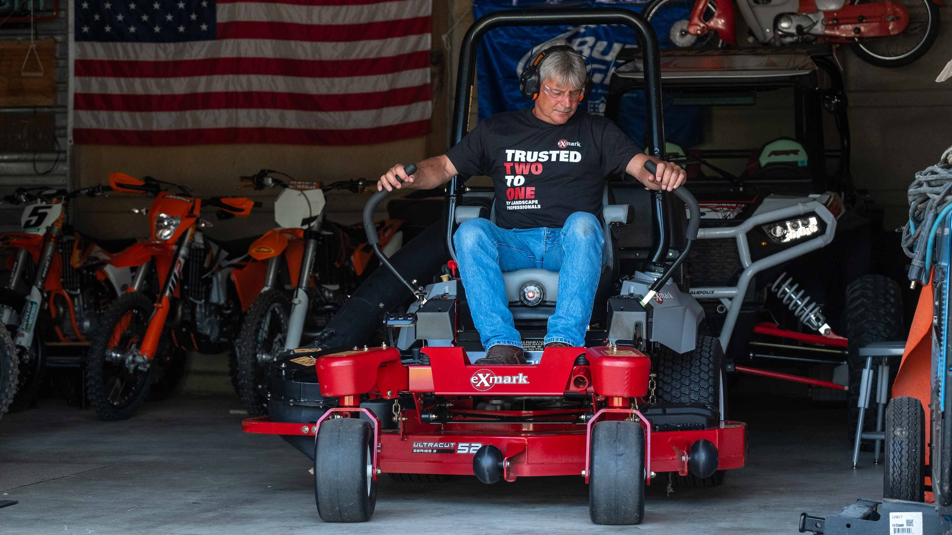 Man on Exmark mower in garage