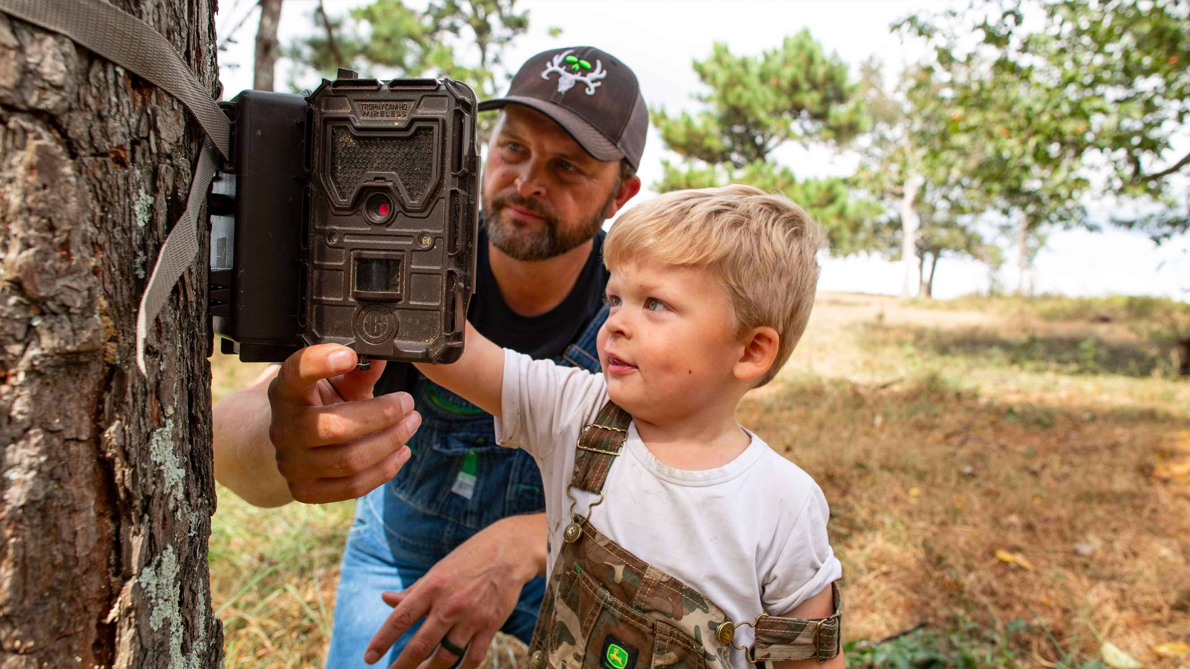 Michael setting up trail cam with son