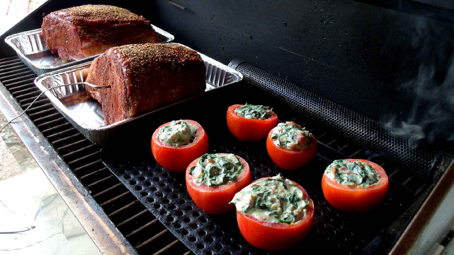 Stuffed tomatoes and meat on grill