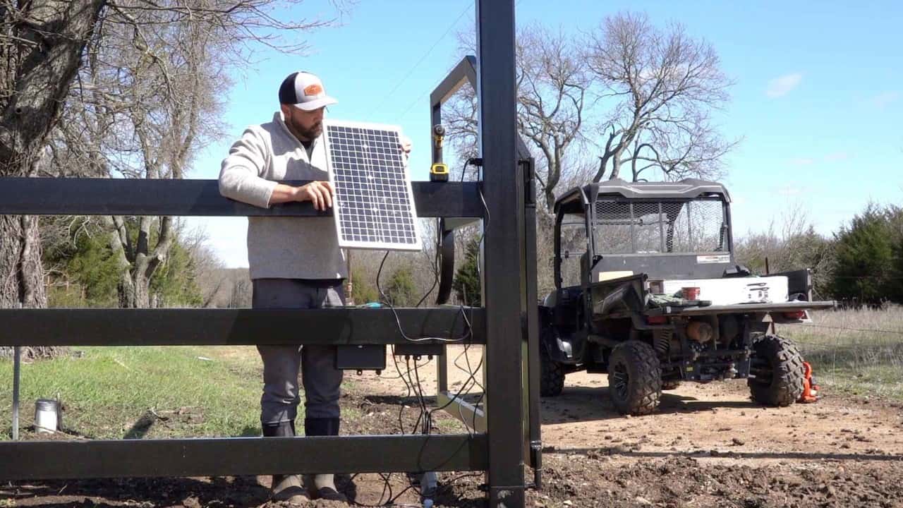 Daniel installing solar panel on automatic gate