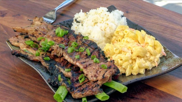 Ribs, mac and cheese, and rice on a dinner plate