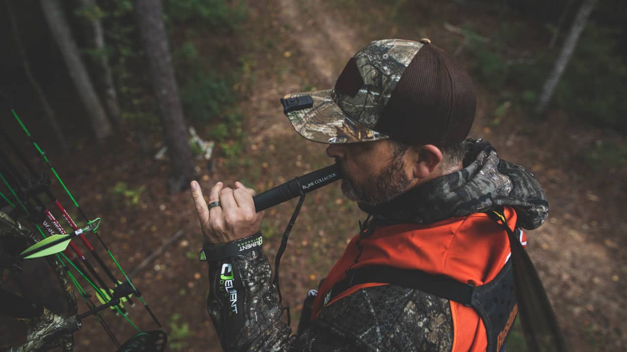 Man using a hunting call in the woods
