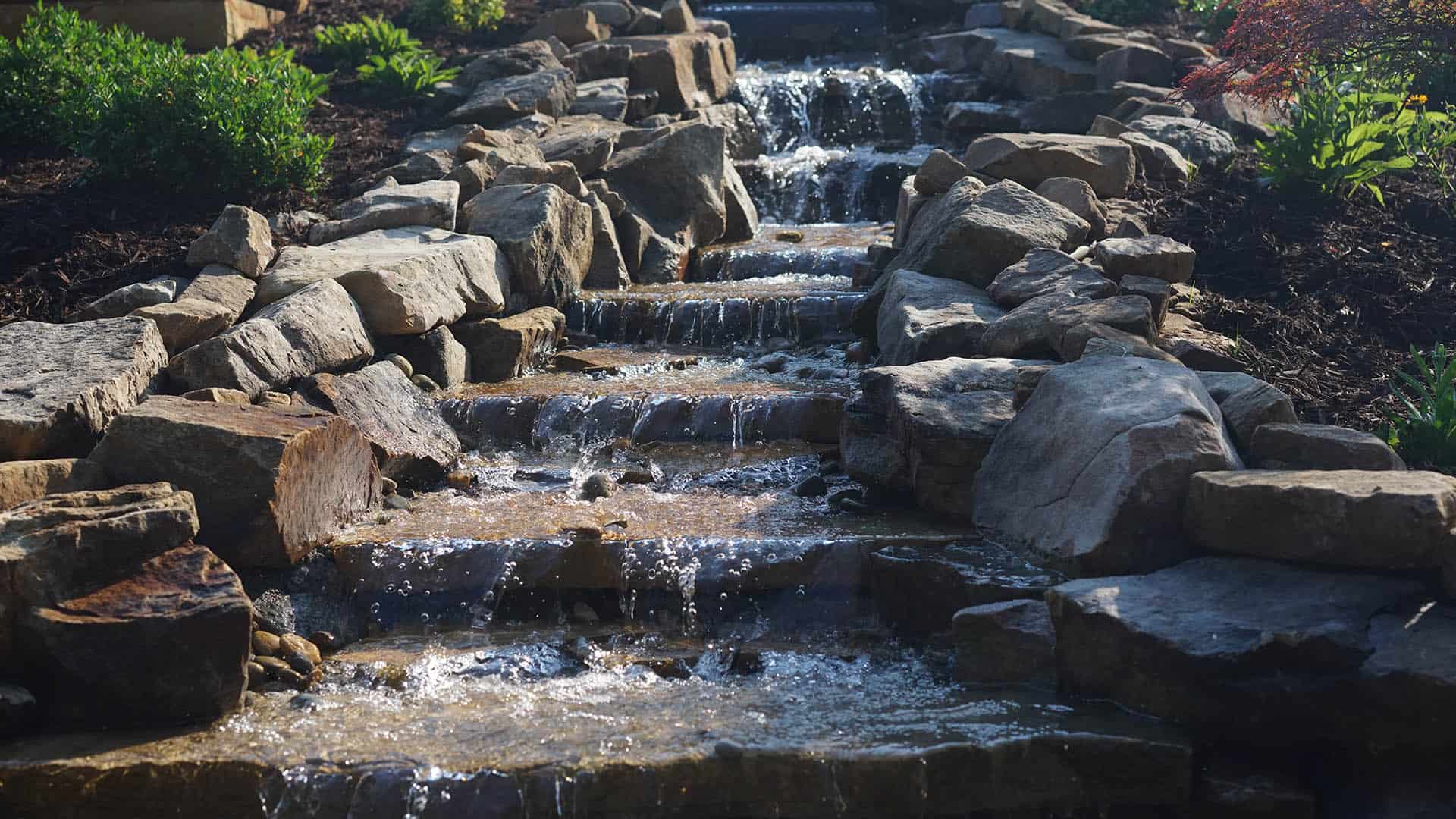 Adding a backyard waterfall is a great way to bring the sounds of nature to into your landscape.