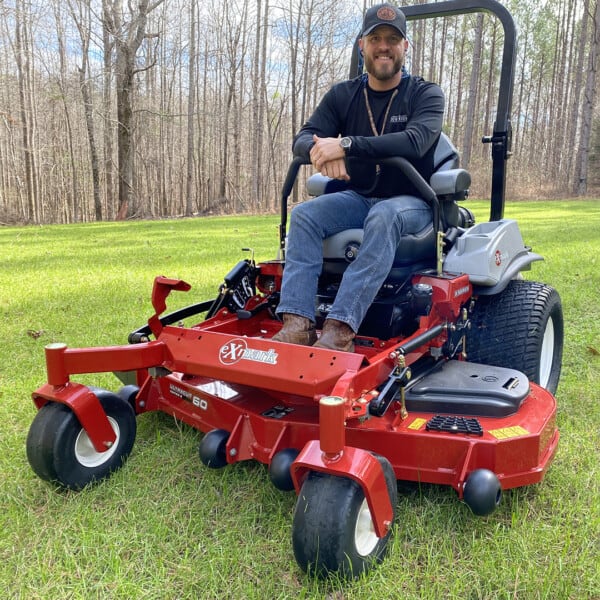 David Bancroft sitting on mower in field