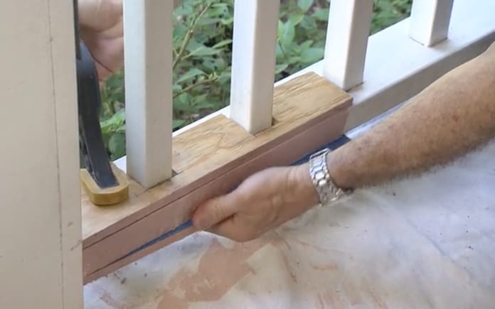 A person repairing a wooden railing