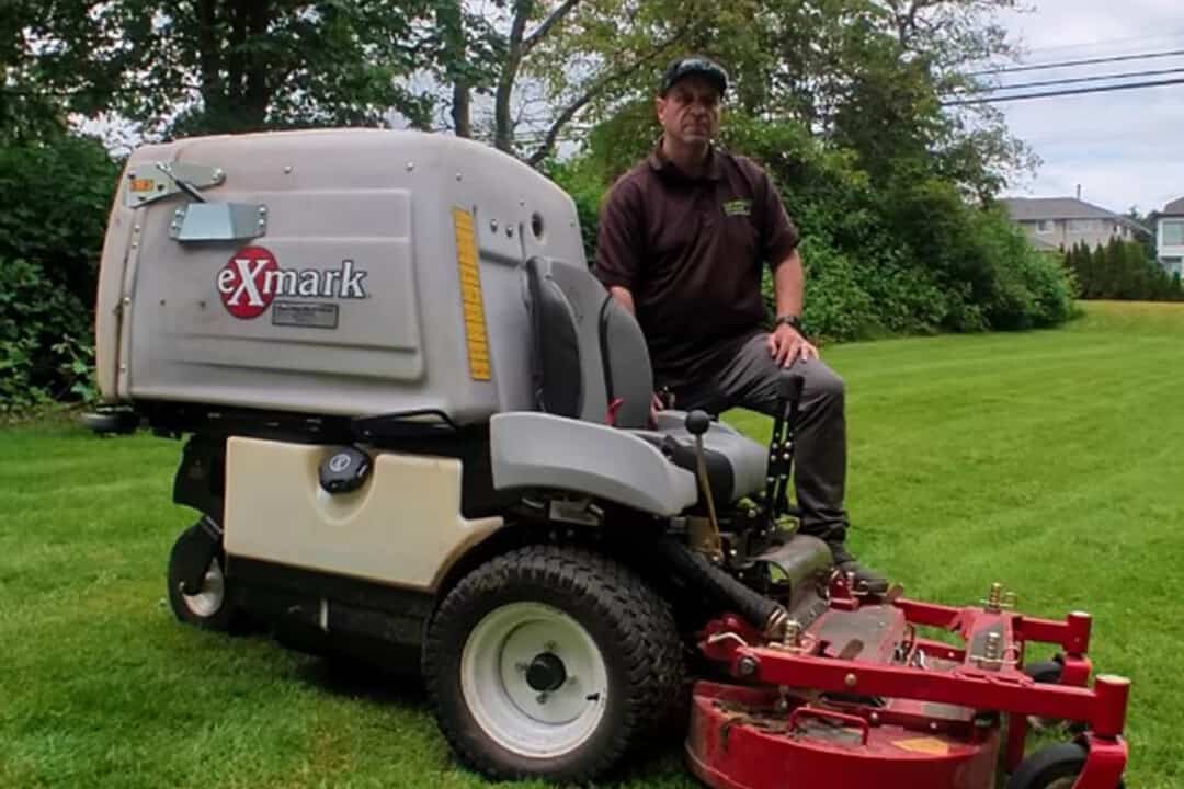 Julio Tome posing with his Exmark mower