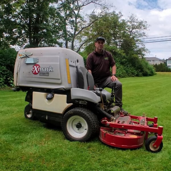 Julio Tome posing with his Exmark mower