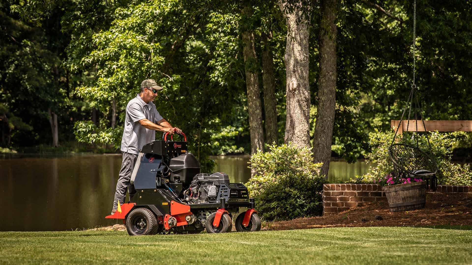 Man standing on exmark aerator using it in yard